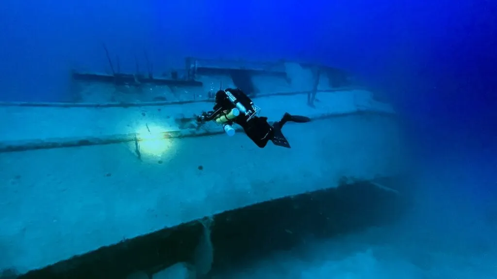 A diver on a closed-circuit rebreather over the reef